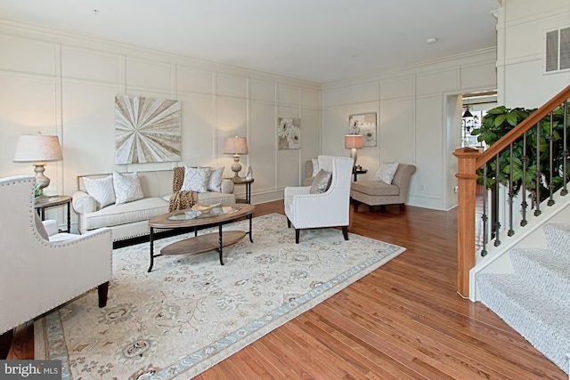 living room featuring hardwood / wood-style flooring and ornamental molding