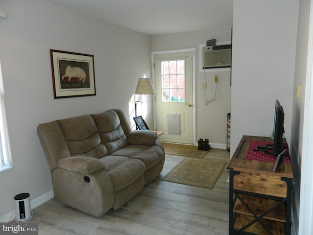 living room featuring light hardwood / wood-style floors and a wall mounted AC