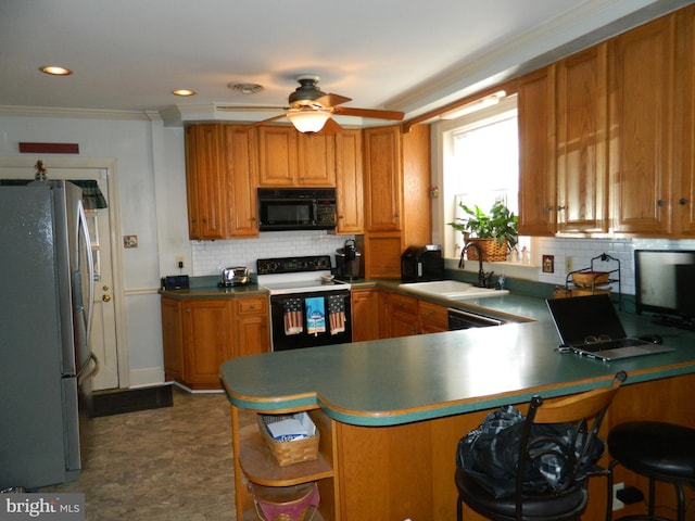 kitchen with sink, range with electric stovetop, stainless steel refrigerator, kitchen peninsula, and decorative backsplash