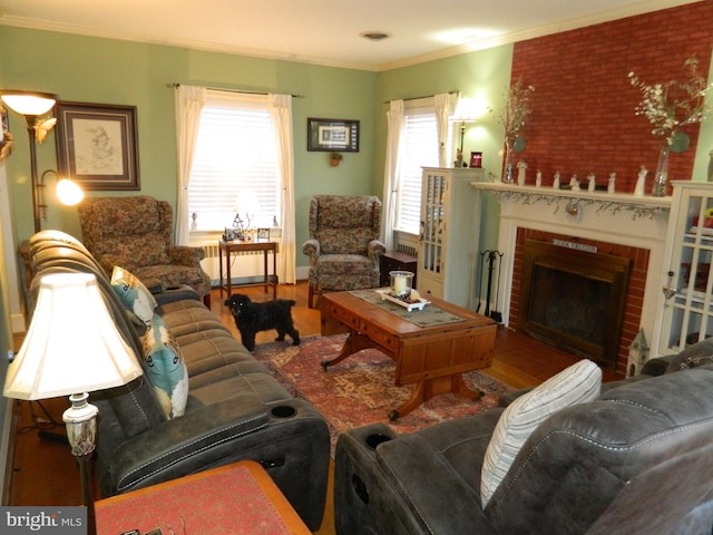 living room featuring a brick fireplace, hardwood / wood-style flooring, and ornamental molding