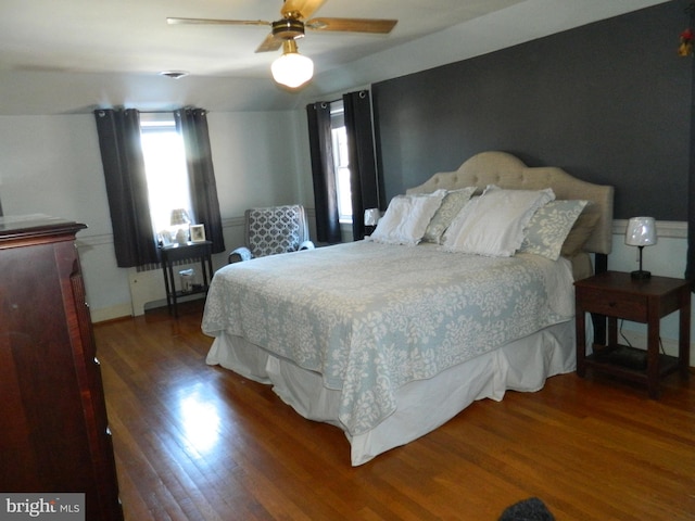 bedroom with dark hardwood / wood-style flooring and ceiling fan