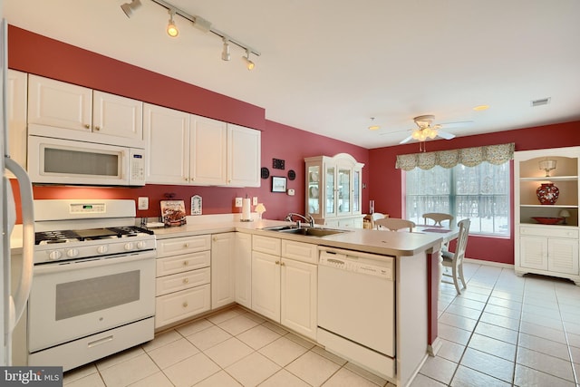 kitchen featuring white appliances, light tile patterned floors, white cabinets, and kitchen peninsula