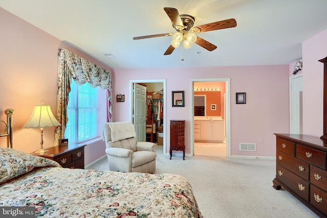 carpeted bedroom with a closet, ceiling fan, sink, a walk in closet, and ensuite bathroom