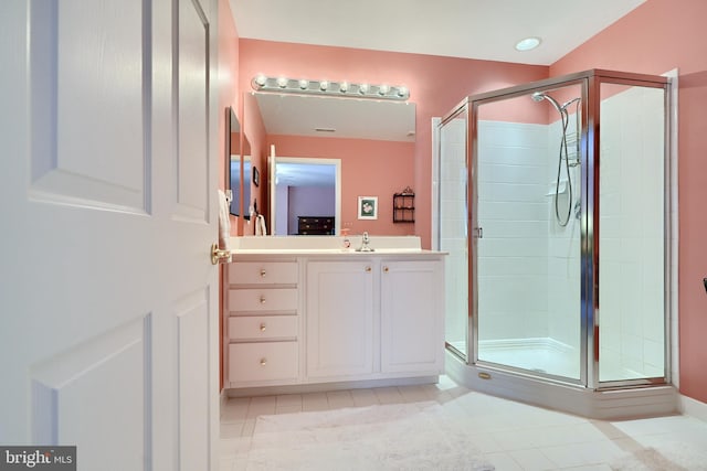 bathroom with an enclosed shower, vanity, and tile patterned floors