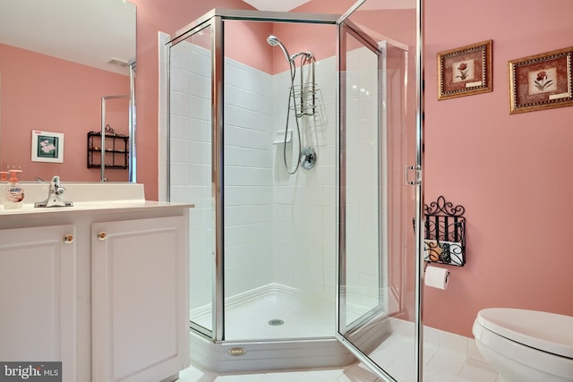 bathroom featuring vanity, tile patterned flooring, toilet, and a shower with shower door