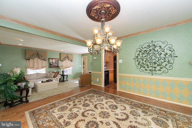 unfurnished dining area featuring wood-type flooring, crown molding, and an inviting chandelier