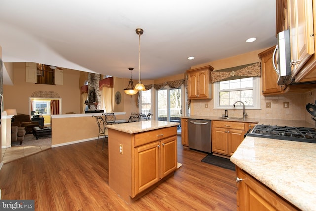 kitchen featuring dark wood-type flooring, hanging light fixtures, stainless steel appliances, and a kitchen island