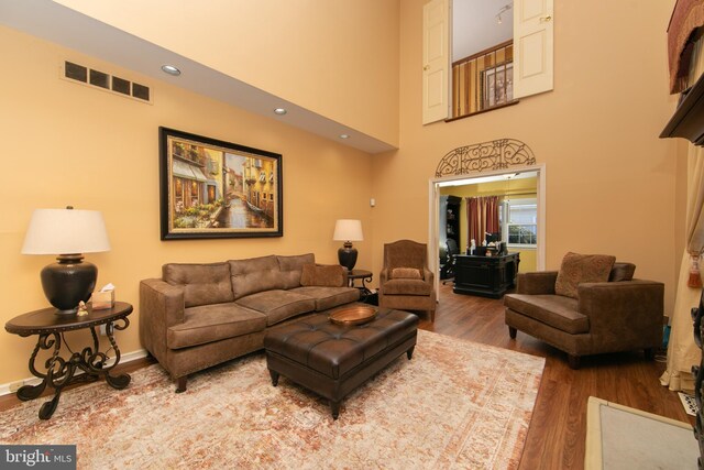 living room with a high ceiling and wood-type flooring