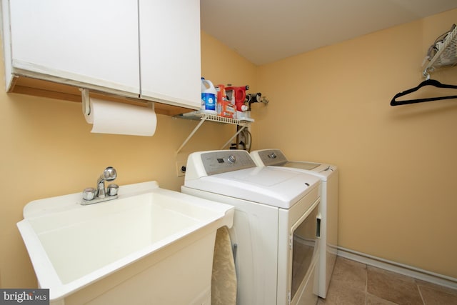 laundry area featuring washing machine and dryer, cabinets, and sink