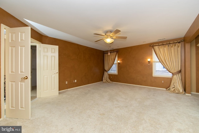 carpeted spare room featuring ceiling fan