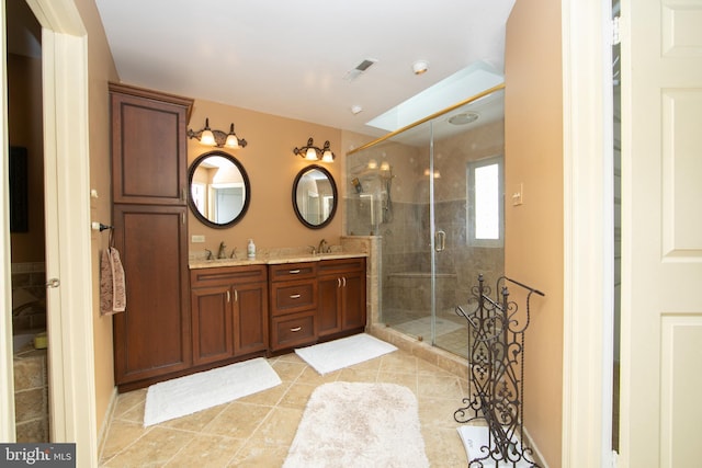 bathroom with an enclosed shower, vanity, a skylight, and tile patterned floors