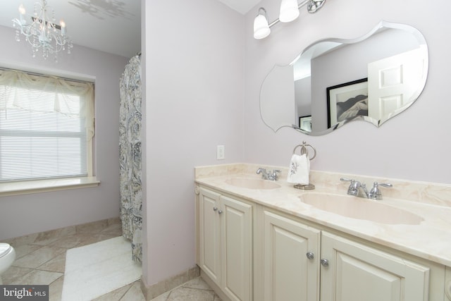 bathroom with toilet, tile patterned floors, vanity, and a chandelier