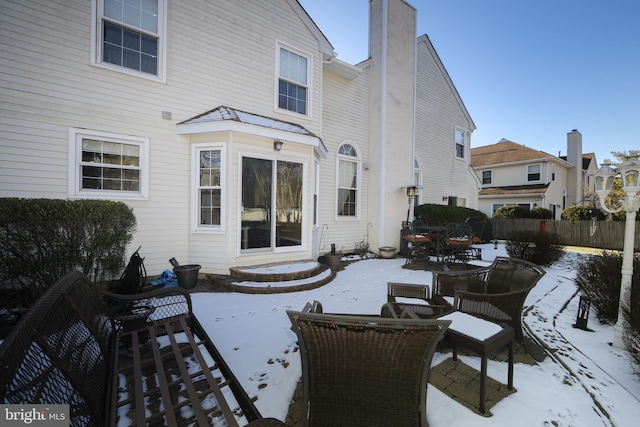 view of snow covered back of property