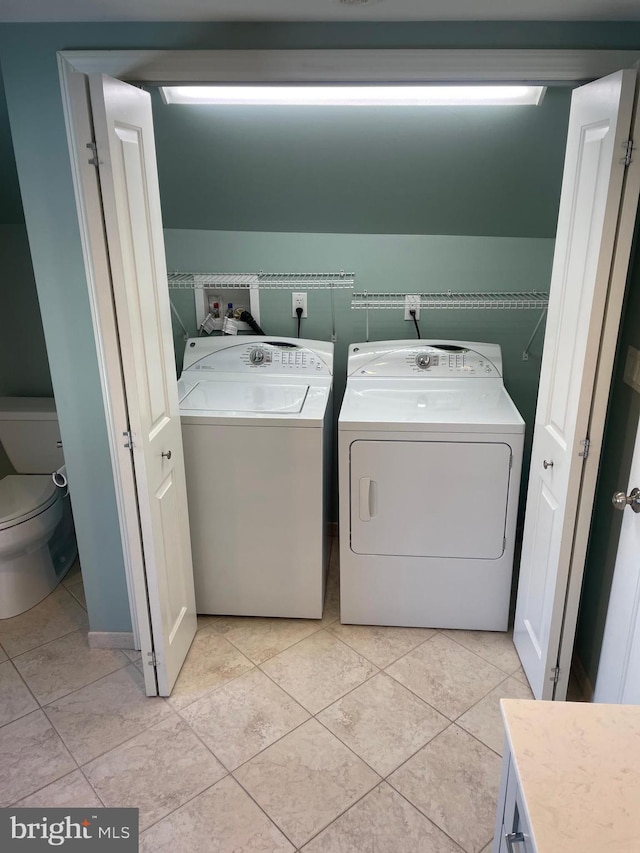 washroom featuring light tile patterned floors and washing machine and dryer