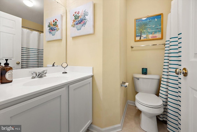 bathroom with toilet, vanity, and tile patterned floors