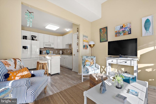 living room featuring sink and light hardwood / wood-style flooring