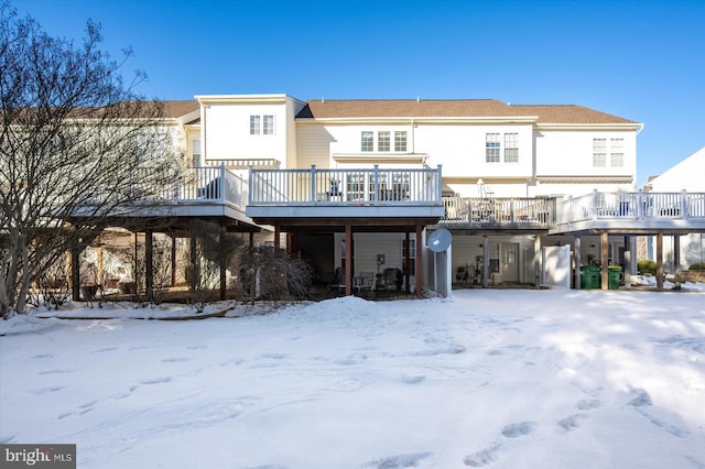 snow covered property with a deck