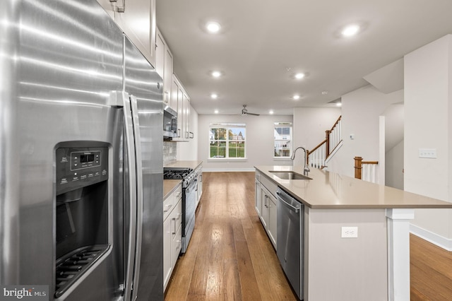 kitchen with a center island with sink, sink, white cabinetry, and stainless steel appliances