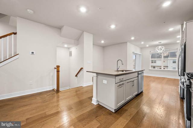 kitchen featuring a center island with sink, light hardwood / wood-style flooring, stainless steel appliances, and sink