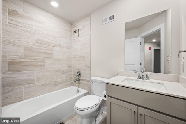 full bathroom with vanity, tiled shower / bath combo, and toilet