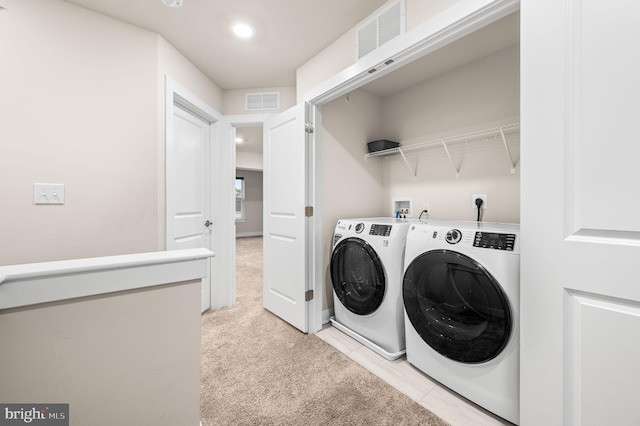 laundry room with light colored carpet and separate washer and dryer