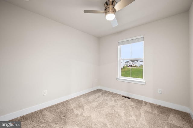 carpeted spare room featuring ceiling fan