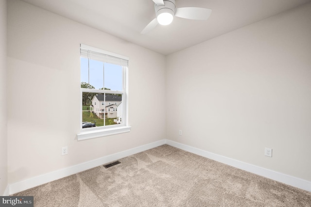 empty room featuring ceiling fan, plenty of natural light, and light colored carpet