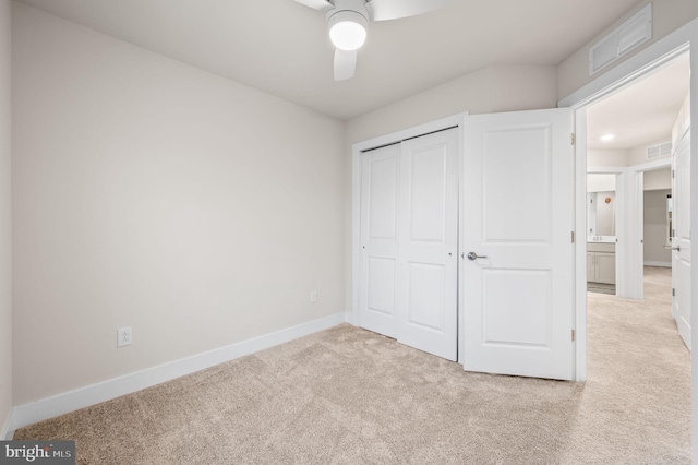 unfurnished bedroom with a closet, ceiling fan, and light colored carpet