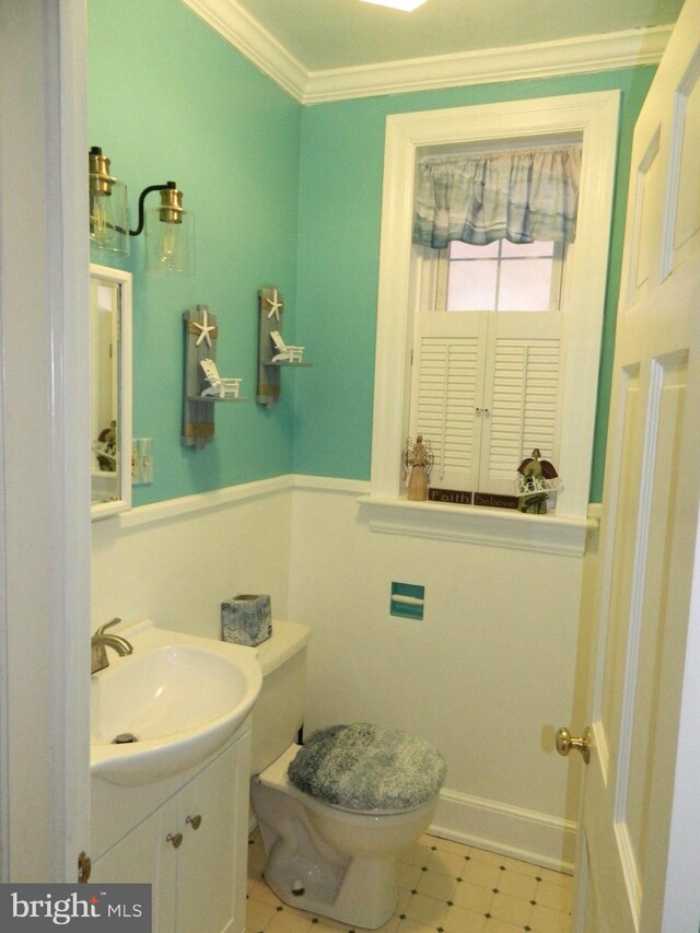 bathroom with vanity, ornamental molding, and toilet