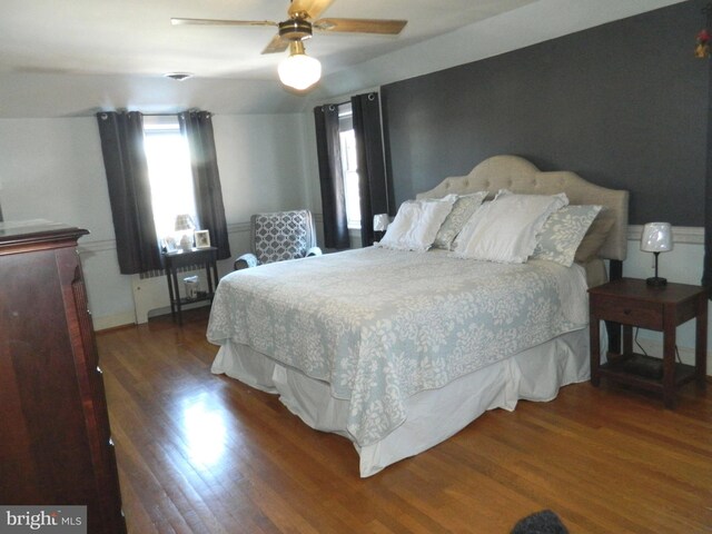 bedroom with ceiling fan and dark hardwood / wood-style flooring