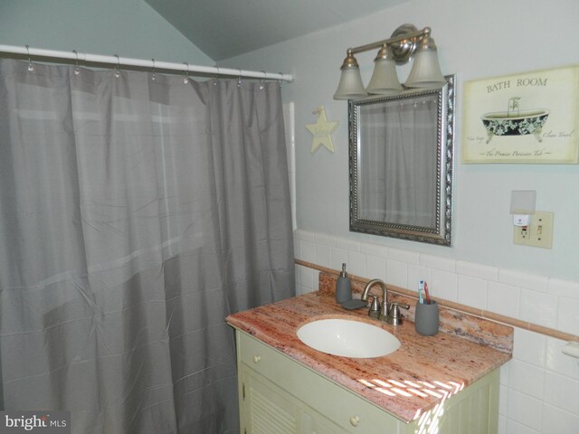 bathroom featuring vanity and tile walls