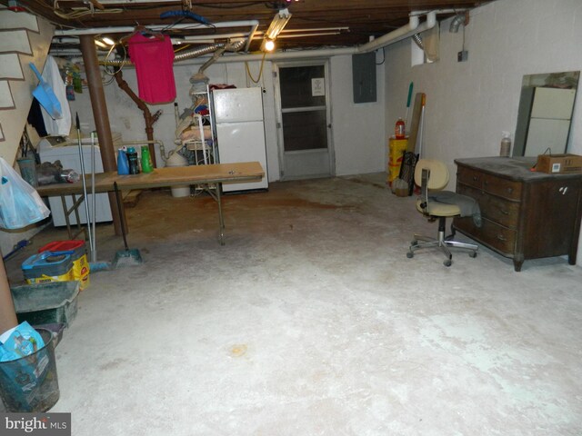 basement with white refrigerator, electric panel, and washer / clothes dryer