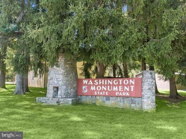 community sign featuring a lawn