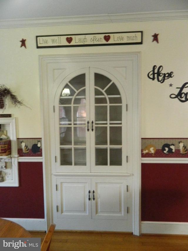 interior details with hardwood / wood-style flooring and ornamental molding