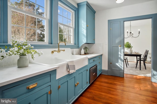 interior space featuring vanity, decorative backsplash, a chandelier, and wood-type flooring