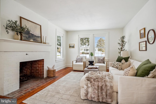 living room featuring light wood-type flooring and a brick fireplace