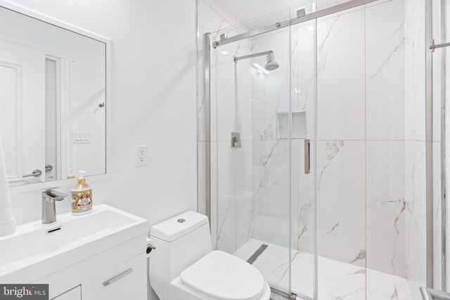 bathroom featuring toilet, vanity, and a shower with shower door