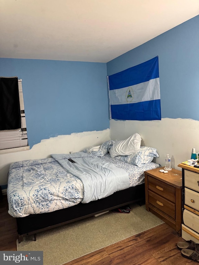 bedroom with dark hardwood / wood-style flooring