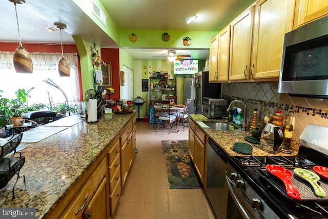 kitchen with pendant lighting, ceiling fan, stainless steel appliances, tasteful backsplash, and light stone countertops