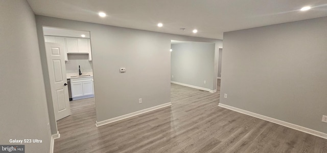 spare room with sink and light hardwood / wood-style floors