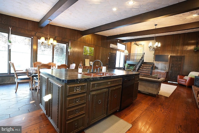 kitchen with hanging light fixtures, a center island with sink, beam ceiling, black dishwasher, and sink