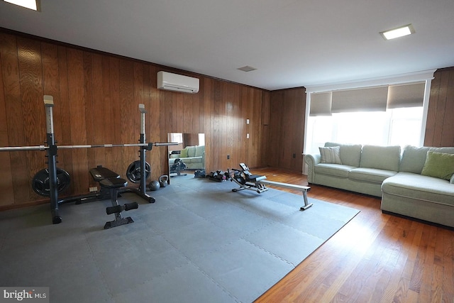 exercise room with a wall unit AC and wooden walls