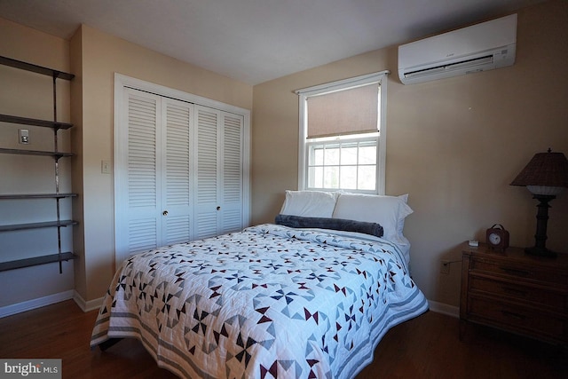 bedroom with a wall unit AC, a closet, and dark wood-type flooring