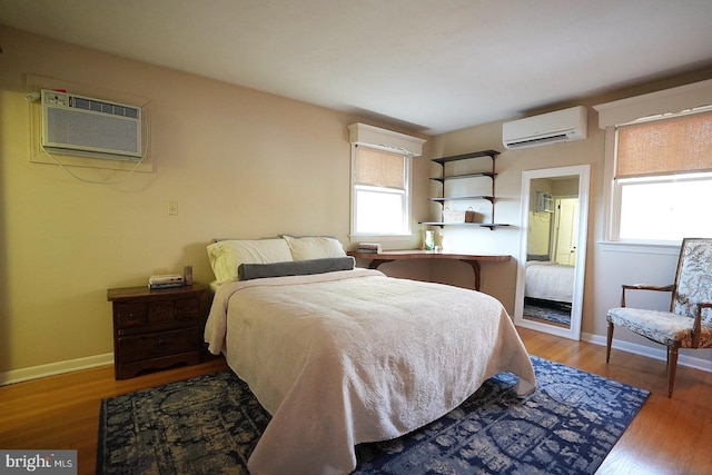 bedroom featuring a wall mounted air conditioner and wood-type flooring