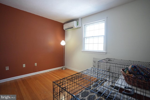 interior space featuring a wall mounted air conditioner and wood-type flooring