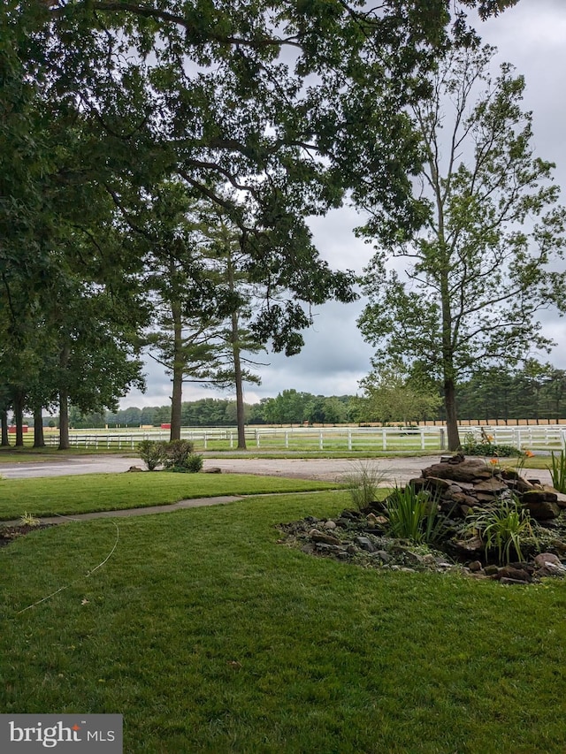 view of property's community featuring a yard and a rural view