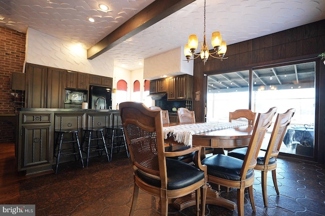 dining room with a textured ceiling, beam ceiling, a notable chandelier, and wooden walls