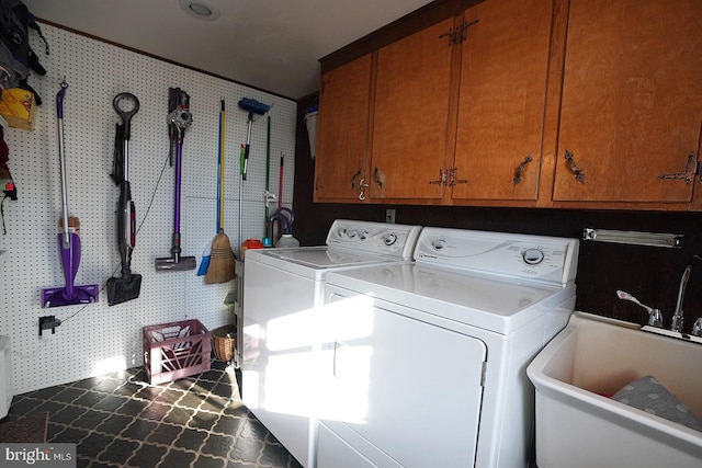 laundry area with sink, washing machine and clothes dryer, and cabinets