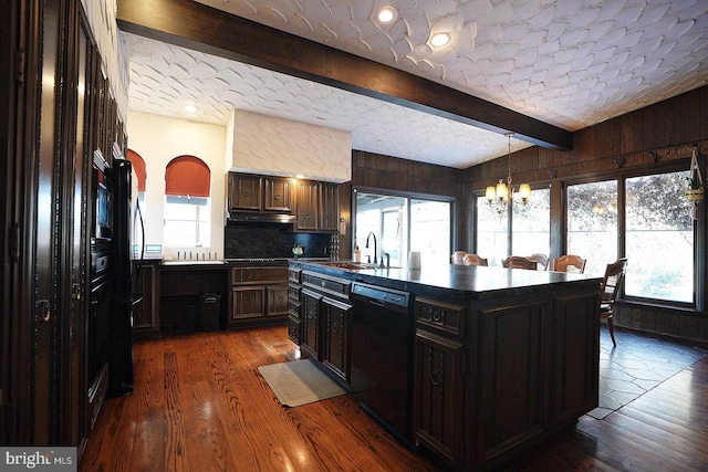 kitchen featuring dark wood-type flooring, dishwasher, a notable chandelier, a kitchen island, and sink