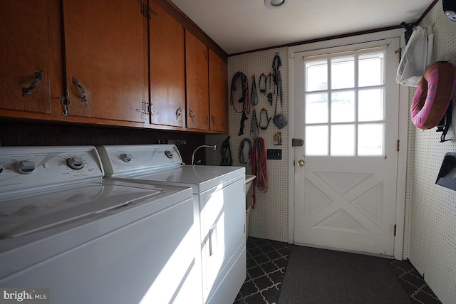 washroom featuring separate washer and dryer and cabinets